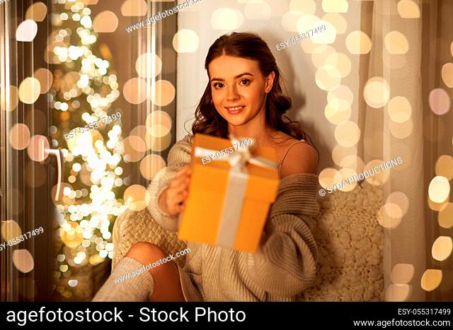 woman with christmas gift at home at night