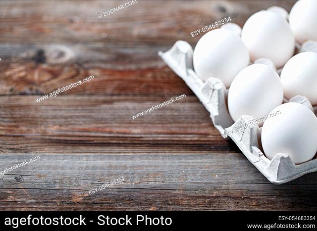 White chicken eggs on old wooden table