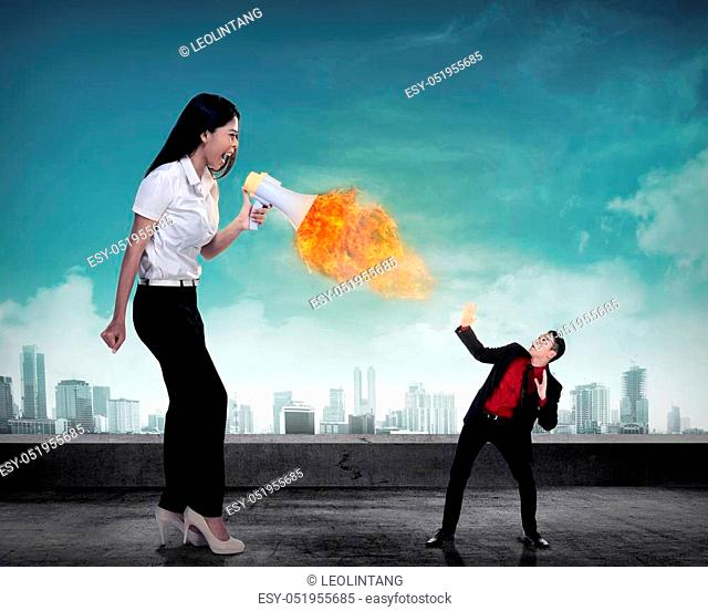 Big boss yelling to her employee with megaphone on fire. Work pressure concept