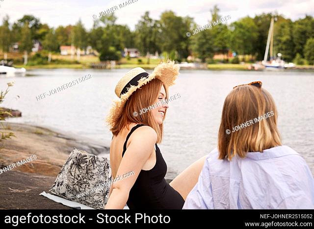 Two friends sitting at lakeside