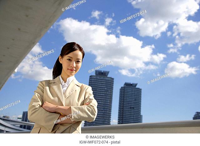 Japan, Honshu, Tokyo, Young businesswoman with arms crossed, portrait