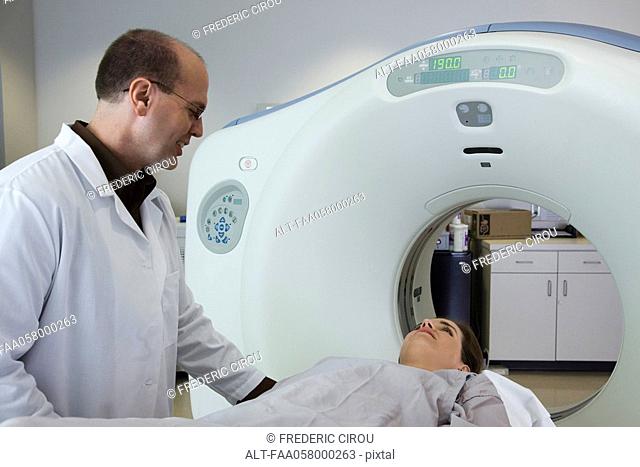 Doctor reassuring nervous female patient preparing to undergo CAT scan