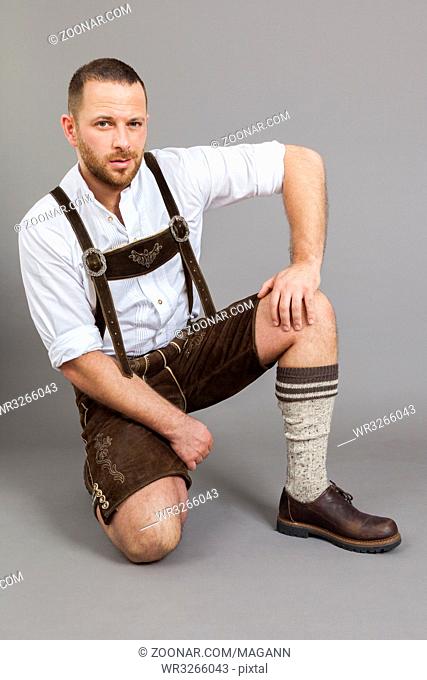 An image of a man in bavarian traditional lederhosen on his knees