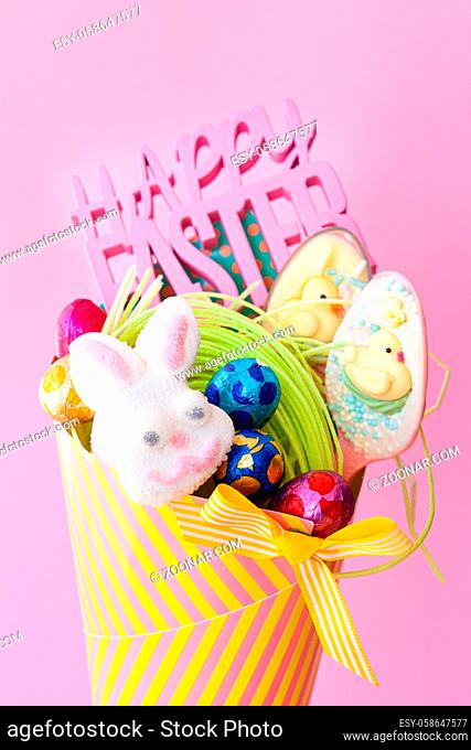 Bunte Tuete mit leckeren Suessigkeiten und Schokolade zu Ostern