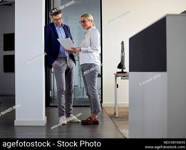 Businessman and businesswoman discussing document at work place