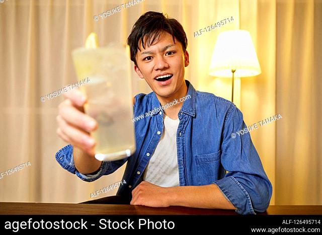 Japanese man drinking at home remote drinking