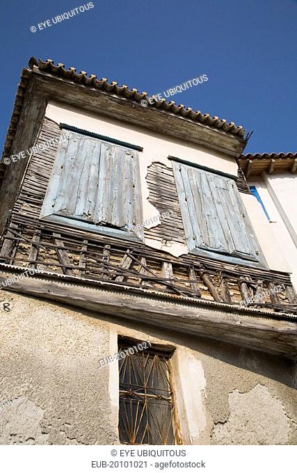 Vathy. Detail of old house with wooden window shutters and exposed timber frame view from below looking upwards
