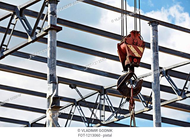 A crane hook attached to cables at a construction site