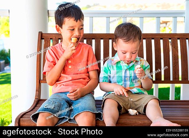 Young Mixed Race Chinese and Caucasian Brothers Enjoying Their Ice Cream Cones