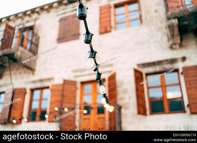 Garland of incandescent lamps against the background of the old villa. High quality photo