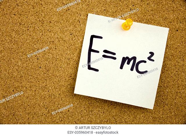 EQUATION E EQUAL MC2 in black ext on a sticky note pinned to a cork notice board