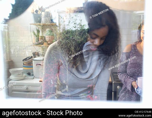 Mother and daughter at kitchen window