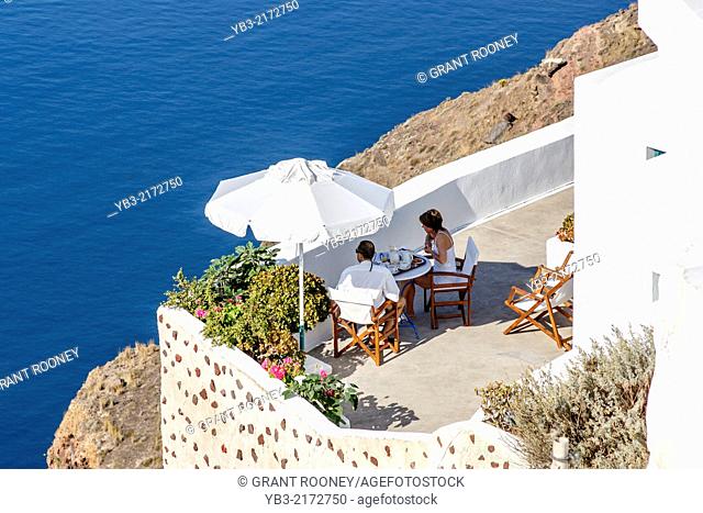 A Couple Eating Breakfast On A Terrace, Oia, Santorini, Greek Islands, Greece