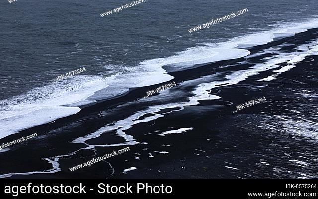 Foamy white waves and icy surfaces on the black pebble beach Skogarsandur, near Dyrholaey, Sudurland, Iceland, Europe