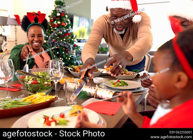 Happy african american family spending time together and having christmas meal