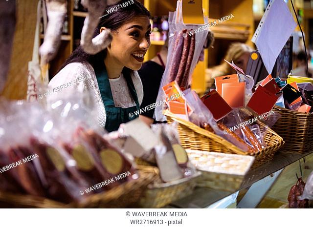 Female staff smiling at meat counter