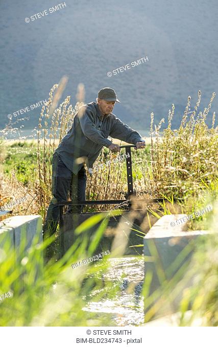 Caucasian farmer adjusting irrigation equipment