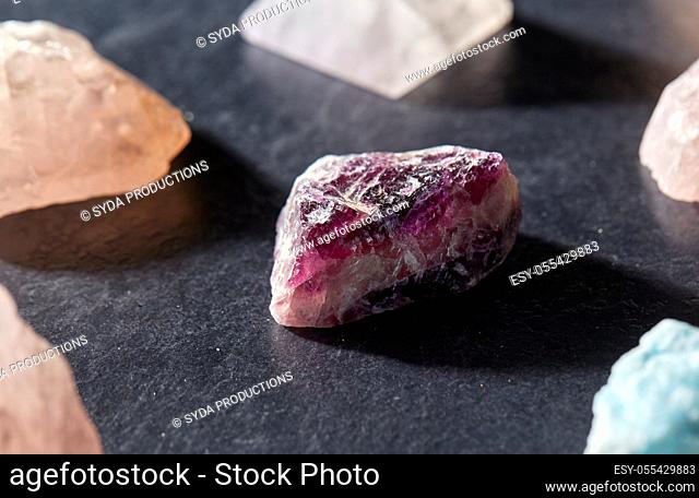quartz crystals and gem stones on slate background