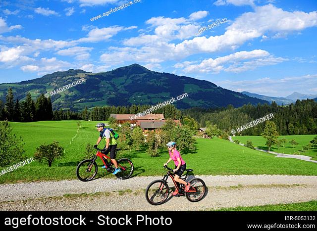 Two cyclists with electric mountain bikes on the Glantersberg with view of the Hohe Salve, Kitzbühel Alps, Tyrol, Austria, Europe