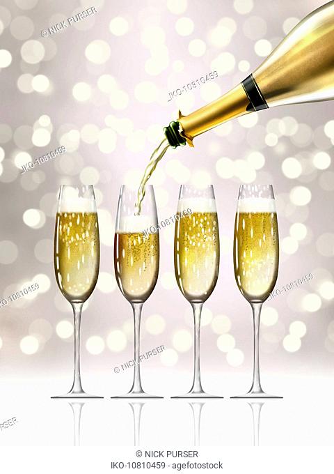 Gold champagne bottle filling sparkling champagne flutes
