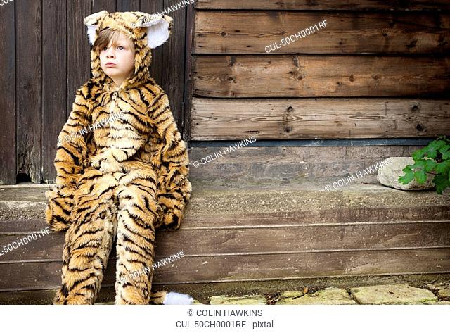 Boy wearing tiger costume outdoors