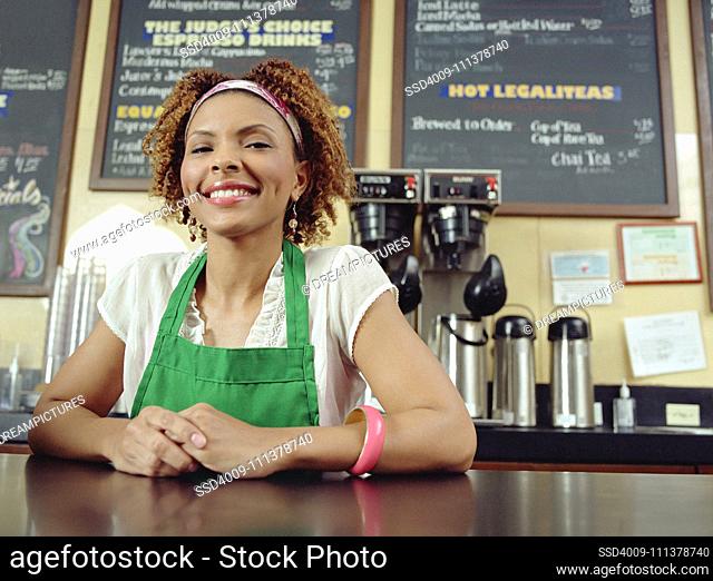 Waitress smiling at counter in coffee shop