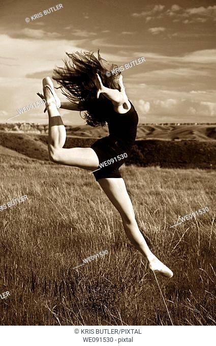 Ballerina jumping in a field