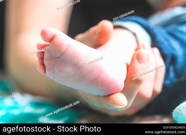 Close up of mother?s hands, holding newborn baby feet