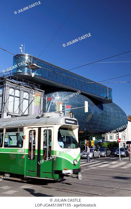 Austria, Styria, Graz. A traditional tram passes the Kunsthaus Graz art house