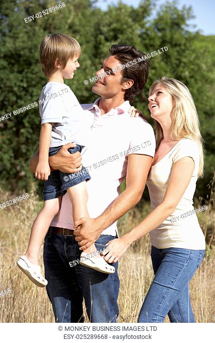 Young Family Walking Through Summer Countryside