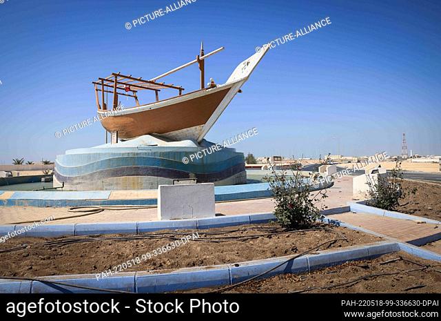 02 April 2022, Qatar, Al Ruwais: An old dhow fishing boat stands on a traffic island with a traffic circle in the small port town of Al Ruwais