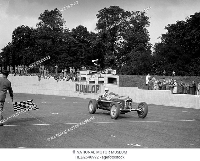 Alfa Romeo of Kenneth Evans taking the chequered flag at Crystal Palace, 1939. Artist: Bill Brunell