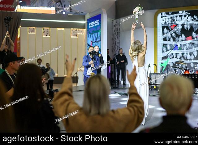 RUSSIA, MOSCOW - NOVEMBER 16, 2023: Bride Arina Belova throws a bouquet during a wedding ceremony at the opening of Kemerovo Region Day as part of the Russia...