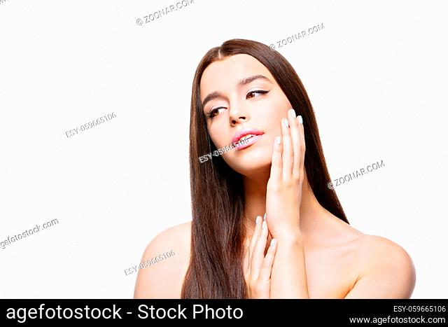 Beautiful young woman looking to side and touching face. Isolated over white background. Copy space