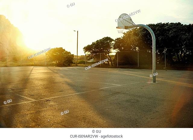 Sunlit basketball net and court