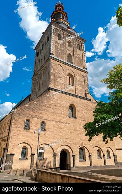 Portal of the Romanesque basilica Saint Ursula with blue sky and small white clouds, Cologne, Germany