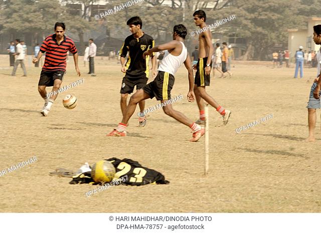 Indian boys playing football on playground ; Bombay Mumbai ;  Maharashtra ; India