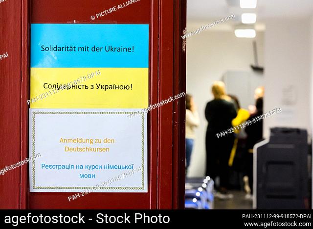 09 November 2023, Berlin: Signs reading ""Registration for German courses"" and ""Solidarity with Ukraine"" hang on the door of a Berlin language school