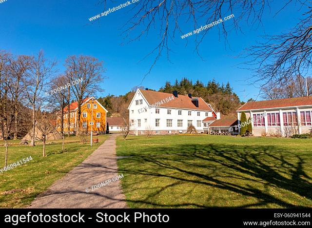 Old Sogne Rectory. Wooden buildings in Sogne, Vicarage is now used as a Cultural Center. Vest-Agder in Norway. Blue sky, green grass