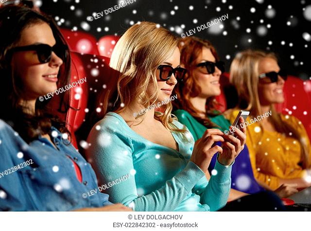 cinema, technology, entertainment and people concept - happy woman in 3d glasses reading message on smartphone in movie theater with friends over snowflakes