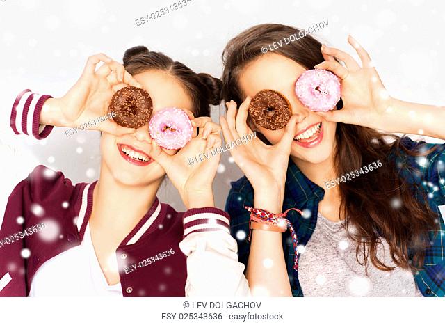 winter, christmas, people, holidays and fast food concept - happy smiling pretty teenage girls or friends with donuts making faces and having fun over gray...