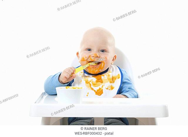 Baby boy 6- 11 Months eating baby food with baby spoon
