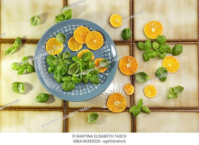 Tangerines and basil on blue plate