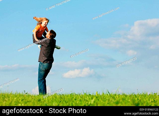 Vater und Tochter auf Wiese im Sommer