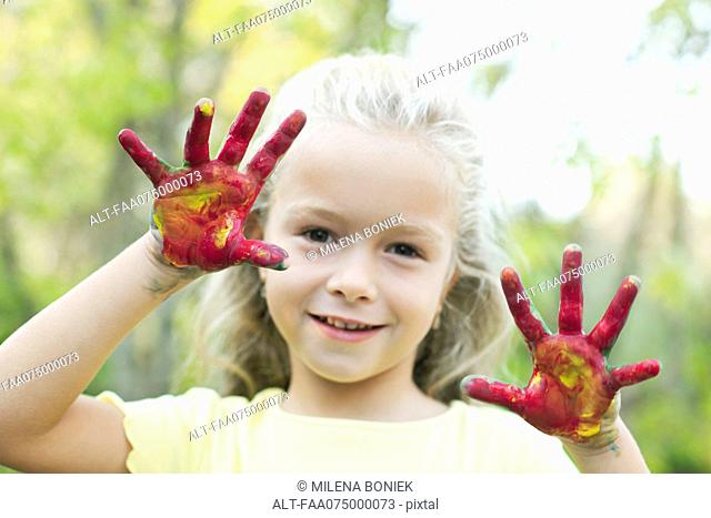 Girl with paint covered hands, portrait