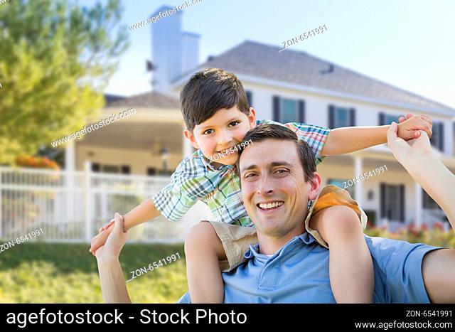 Mixed Race Father and Son Playing Piggyback in Front of Their House