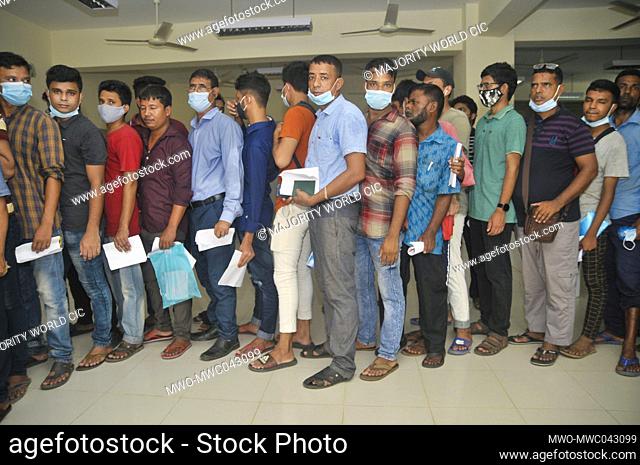 Sylhet, Bangladesh. 14th October 2021. People looking to travel overseas stand in a long queue to receive the Pfizer-BioNTech Covid-19 Vaccine at the M A G...
