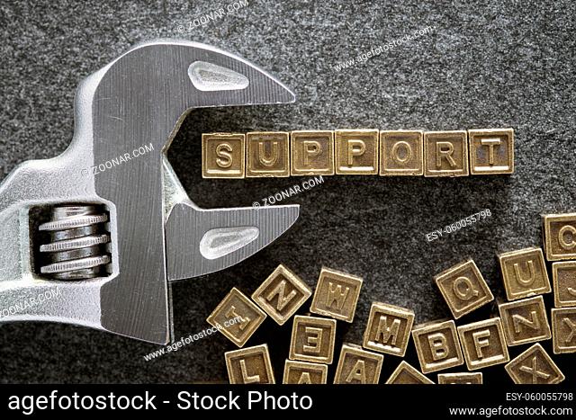 support word made from variety metallic blocks with adjustable wrench on blackboard