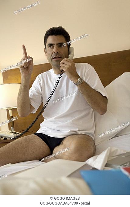 Man talking on phone in hotel room