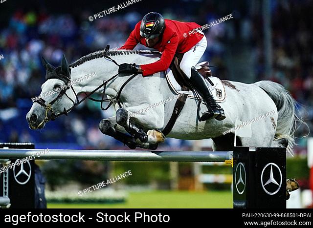 30 June 2022, North Rhine-Westphalia, Aachen: Equestrian sport, jumping: CHIO, Nations Cup. German show jumper Christian Kukuk on horse Mumbai jumps over an...